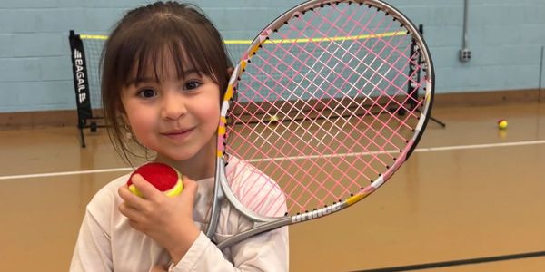 Kids at a tennis lesson with a coach